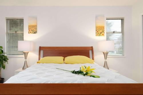 a bedroom with a bed with yellow pillows and two lamps at Private Room with Full Amenities in Cozy House in Vancouver