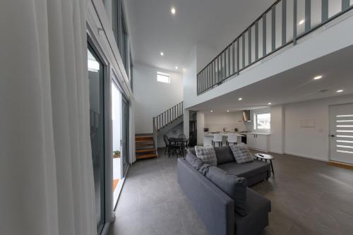 a living room with a couch and a staircase at Private Mezzanine Bedroom, Soaring Ceilings, Sleeps 3, Walk to Cafes, 15 min to Bunbury in Australind