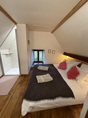 a large bedroom with a large bed with red pillows at Domaine du Manoir de Vains in Vains