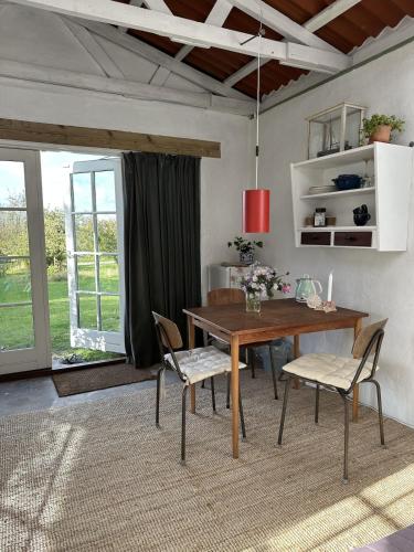 a dining room with a wooden table and chairs at Camønogaarden B&B, darksky cabins and events in Borre