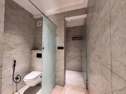 a bathroom with a toilet and a glass shower stall at Sanskar Resort in Pānāgar