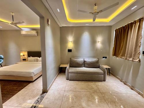 a bedroom with a bed and a couch and a chair at Sanskar Resort in Pānāgar