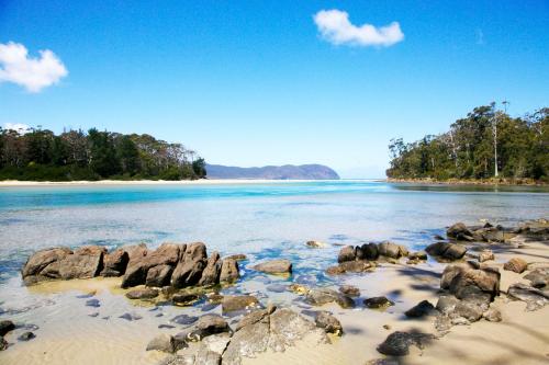 a view of a beach with rocks in the water at Cloudy Bay Villa in South Bruny