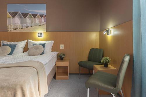 a hotel room with a bed and a chair at PREMIUM B&B Nova Gorica, Self Check-In with code access in Nova Gorica
