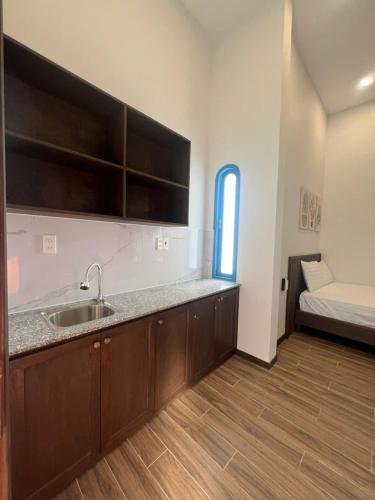 a kitchen with a sink and a bed in a room at Nhã Hotel A in Thôn Mỹ Phước