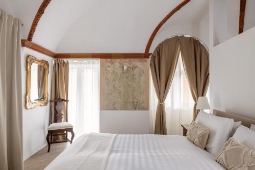 a bedroom with a white bed and a window at Schloss Locarno - Suites & Apartments in Locarno