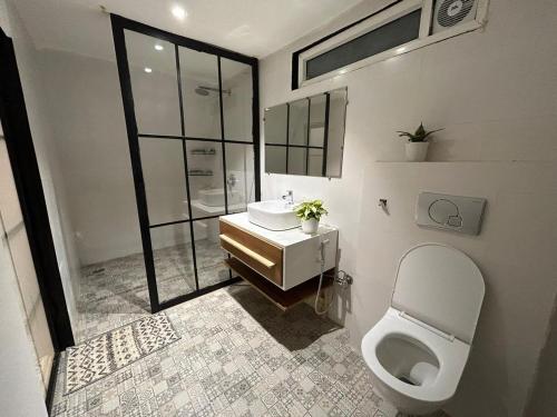 a bathroom with a white toilet and a sink at The Alchemist Rishikesh in Birbhaddar