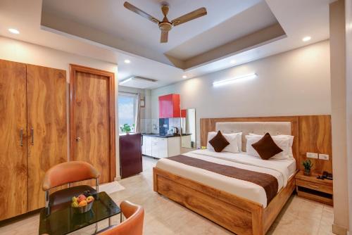 a bedroom with a large bed and a kitchen at The Palm Suites - Medicity in Gurgaon