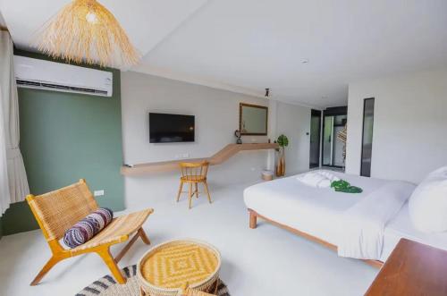 a bedroom with a bed and a table and chairs at HOTEL NUU CHIANG MAI in Chiang Mai