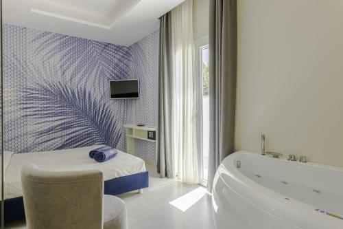 a bathroom with a tub and a bed and a bath tub at Le Gemelle Boutique Hotel in Torre Suda