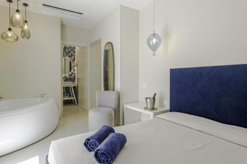 a bedroom with a tub and a bed with towels at Le Gemelle Boutique Hotel in Torre Suda