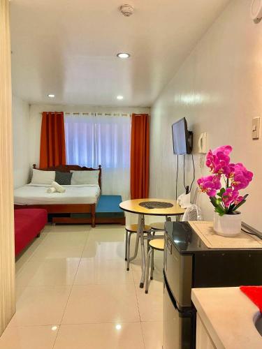 a living room with a bed and a table with flowers at 2B-15 Condo Staycation at Megatower 1 in Baguio