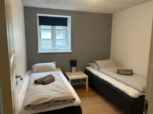 a bedroom with two beds and a window at Kærskovgård ferielejligheder in Faxe