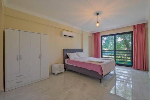 a bedroom with a bed and a large window at Villa Ana in Kızılyurd
