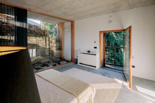 a room with a bed and a large window at Quinta do Vale da Ermida, Private - Heated - Pool in Ermida
