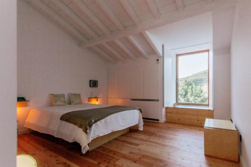 a bedroom with a bed and a large window at Quinta do Vale da Ermida, Private - Heated - Pool in Ermida