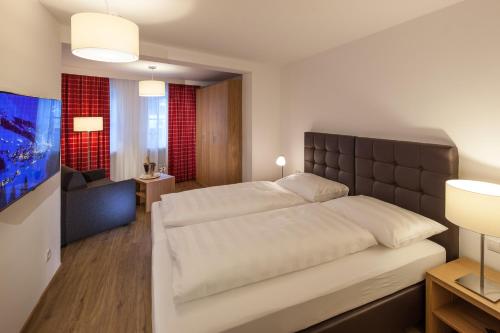 a bedroom with a large bed and a living room at Pfefferkorn's Ferienappartements in Lech am Arlberg