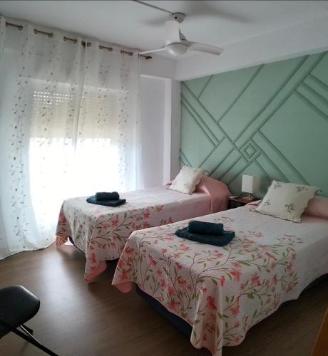 a bedroom with two beds and a window at Ricardo Hostal Apartamento in Alicante