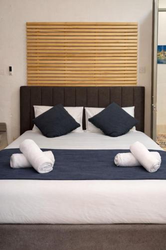 a large bed with two pillows on top of it at Valletta Maisonette Malta in Valletta
