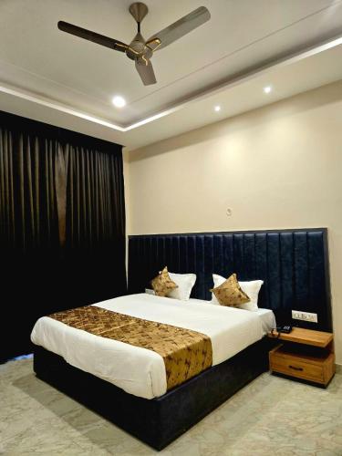a bedroom with a large bed with a ceiling fan at R N Hotel & Lawn in Katra