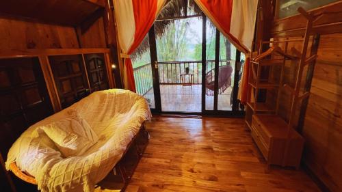 a bedroom with a bed and a large window at Napong Ecolodge in Lung Co (1)