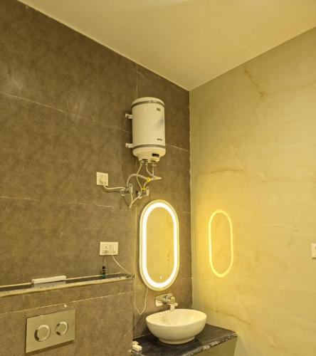 a bathroom with a toilet and a sink and two mirrors at R N Hotel & Lawn in Katra