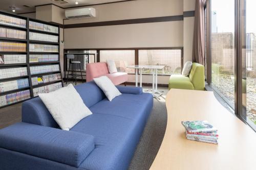 a living room with a blue couch in a library at Mito Hotel Season in Mito