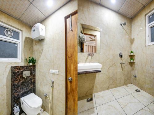 a bathroom with a shower and a toilet and a sink at The Palm Suites - Medicity in Gurgaon