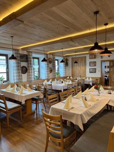 a dining room with white tables and chairs at Gasthaus Stoiber in Buchbach