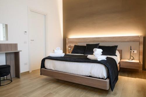 ein Schlafzimmer mit einem großen Bett, auf dem zwei Handtücher liegen in der Unterkunft L'Airone Resort - Soggiorno rilassante in Irpinia in Venticano