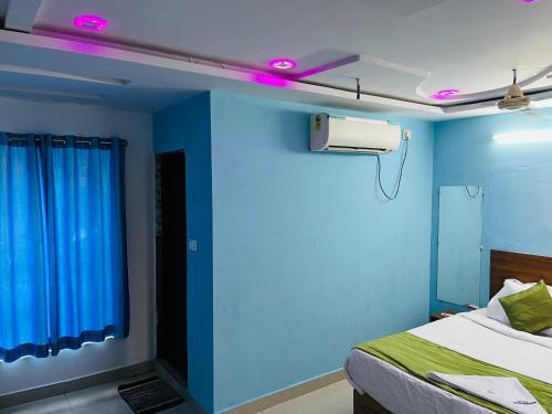 a blue room with a bed and a blue wall at Hotel ANR Grand in Visakhapatnam