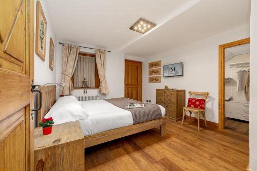 a bedroom with a bed and a chair in it at Maison Carrel Elegant 6 in Breuil-Cervinia