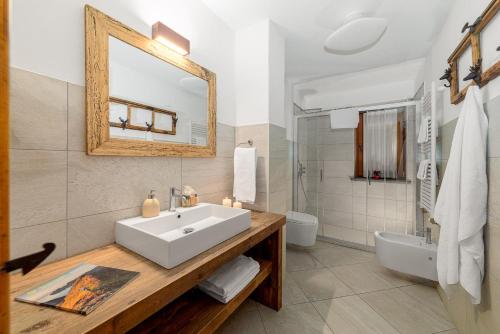 a bathroom with a sink and a toilet and a mirror at Maison Carrel Elegant 6 in Breuil-Cervinia