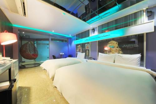 a bedroom with two beds and a room with blue lights at Hotel Campanella in Seoul
