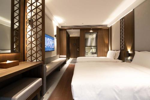 a hotel room with two beds and a tv at Shanghai Qiuzhu Hotel - Near Shanghai Disney Resort & Wildlife Park - Free Buffet Breakfast - Pick-up Service for Disneyland, PVG Airport, Wildlife Park & Xinchang Metro Station in Shanghai