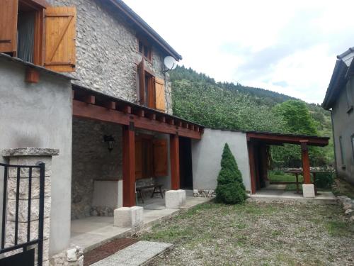 Prades Pyrénées ariegeoise في Entrevennes: منظر خارجي لمبنى به شجرة