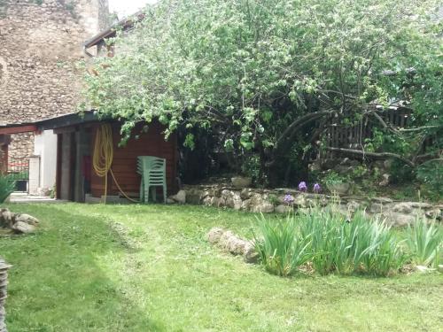 Prades Pyrénées ariegeoise في Entrevennes: حديقة بها كرسي وشجرة