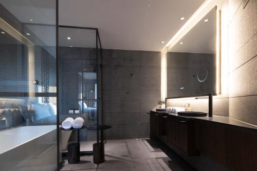 a bathroom with a shower and a sink and a tub at Shanghai Qiuzhu Hotel - Near Shanghai Disney Resort & Wildlife Park - Free Buffet Breakfast - Pick-up Service for Disneyland, PVG Airport, Wildlife Park & Xinchang Metro Station in Shanghai