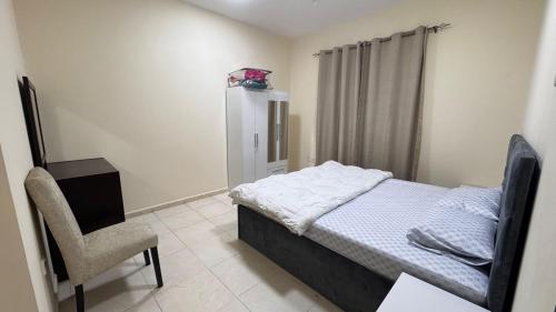 a small bedroom with a bed and a chair at Room for rent daily and monthly in Ajman 