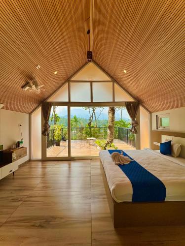 a large bedroom with a large bed with a large window at Hayashi Resort in Meppādi