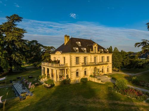 a large house on a grassy field at Garrigae Manoir de Beauvoir Poitiers Sud - Hotel & Spa in Mignaloux-Beauvoir