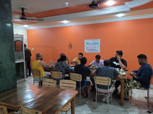 a group of people sitting at tables in a restaurant at New Samrat Hotel & Restaurant in Srīnagar