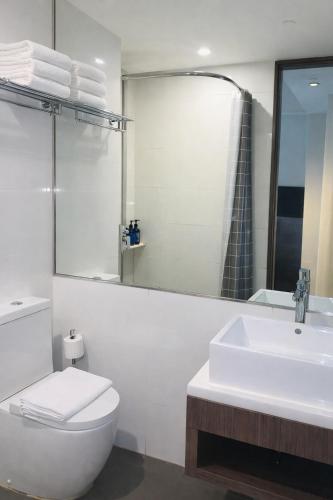 a bathroom with a sink and a toilet and a mirror at Amrise Hotel Kitchener, Check In 9PM, Check Out 8AM in Singapore