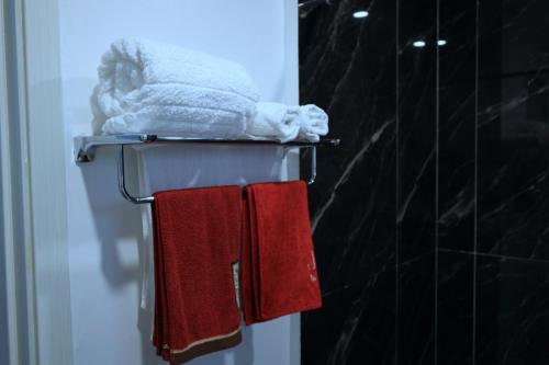 two red towels on a towel rack in a bathroom at GBSL Grand Villa in Nairobi