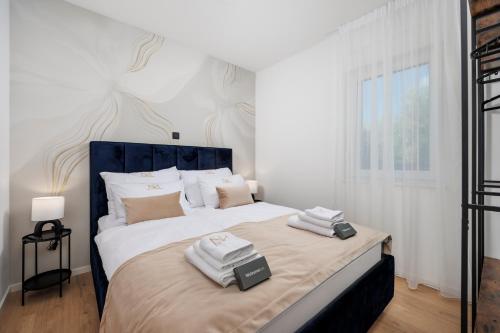 a bedroom with a large bed with two towels on it at Euphoria Animar & Tiema in Draga Bašćanska