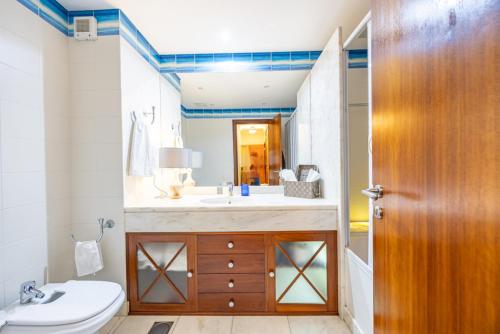 a bathroom with a sink and a toilet and a mirror at Ocean Lido in Funchal
