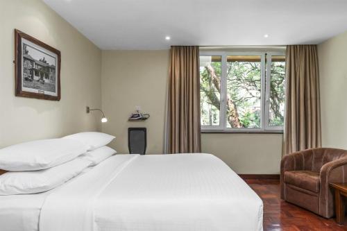 a bedroom with a large white bed and a chair at Best Western Nairobi Upper Hill in Nairobi