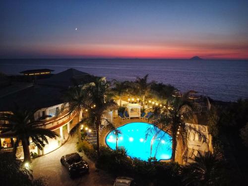 a view of a swimming pool at night at Resort Rocca di Vadaro - Seafront Suites, Rooms & Apartments in Capo Vaticano