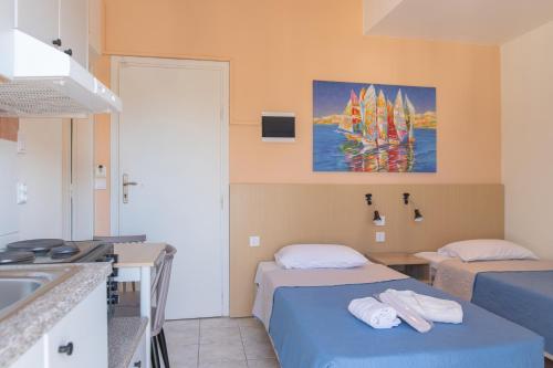 a hotel room with two beds and a sink at Achilleas Hotel Apartments in Kos