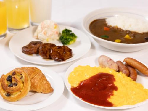 a table topped with plates of food and bowls of soup at Court Hotel Niigata in Niigata